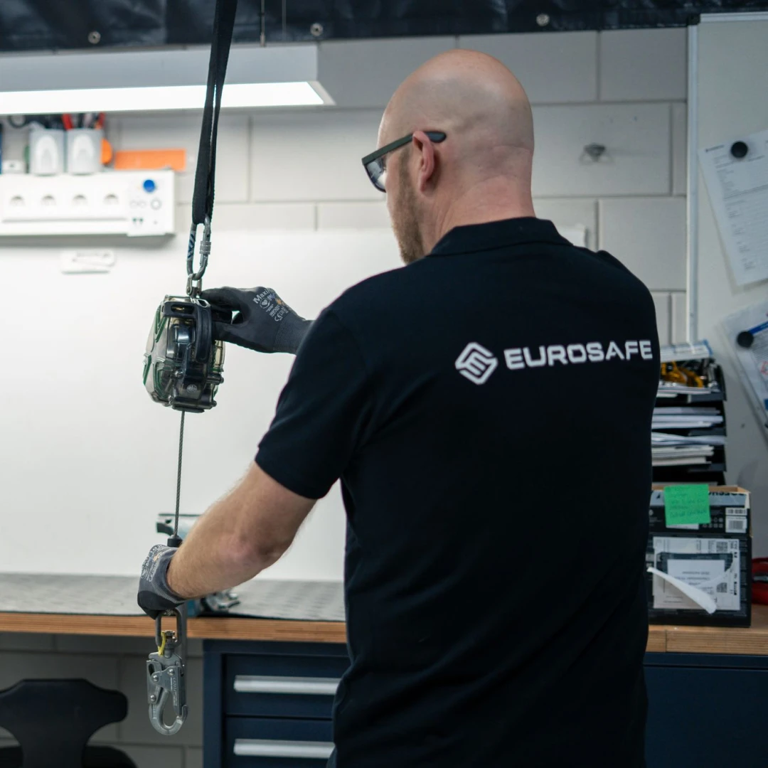 man staat met rug naar camera en houd een valblok vast