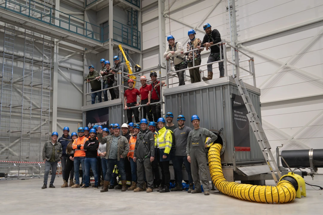 groepsfoto in trainingshal en ze hebben allemaal een helm op