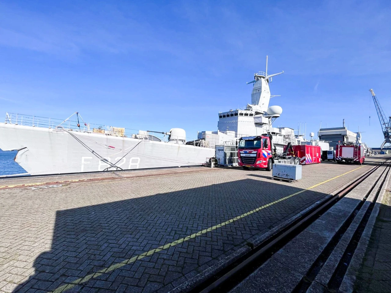 een brandweerwagen in het rood voor een groot schip van de marine