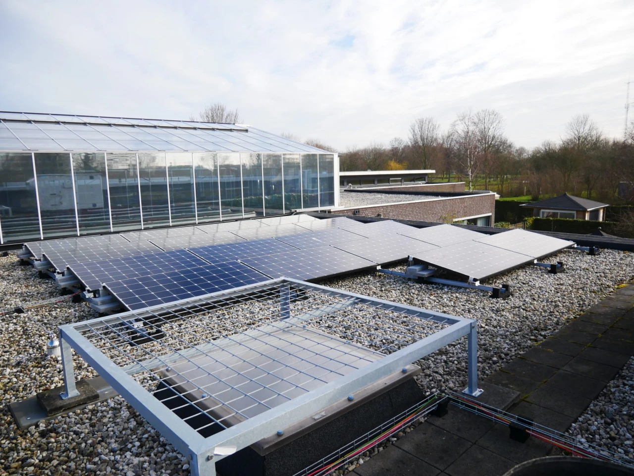 Zonnepanelen en een doorvalveilig rooster over een lichtkoepel – Ny Lankum, Franeker