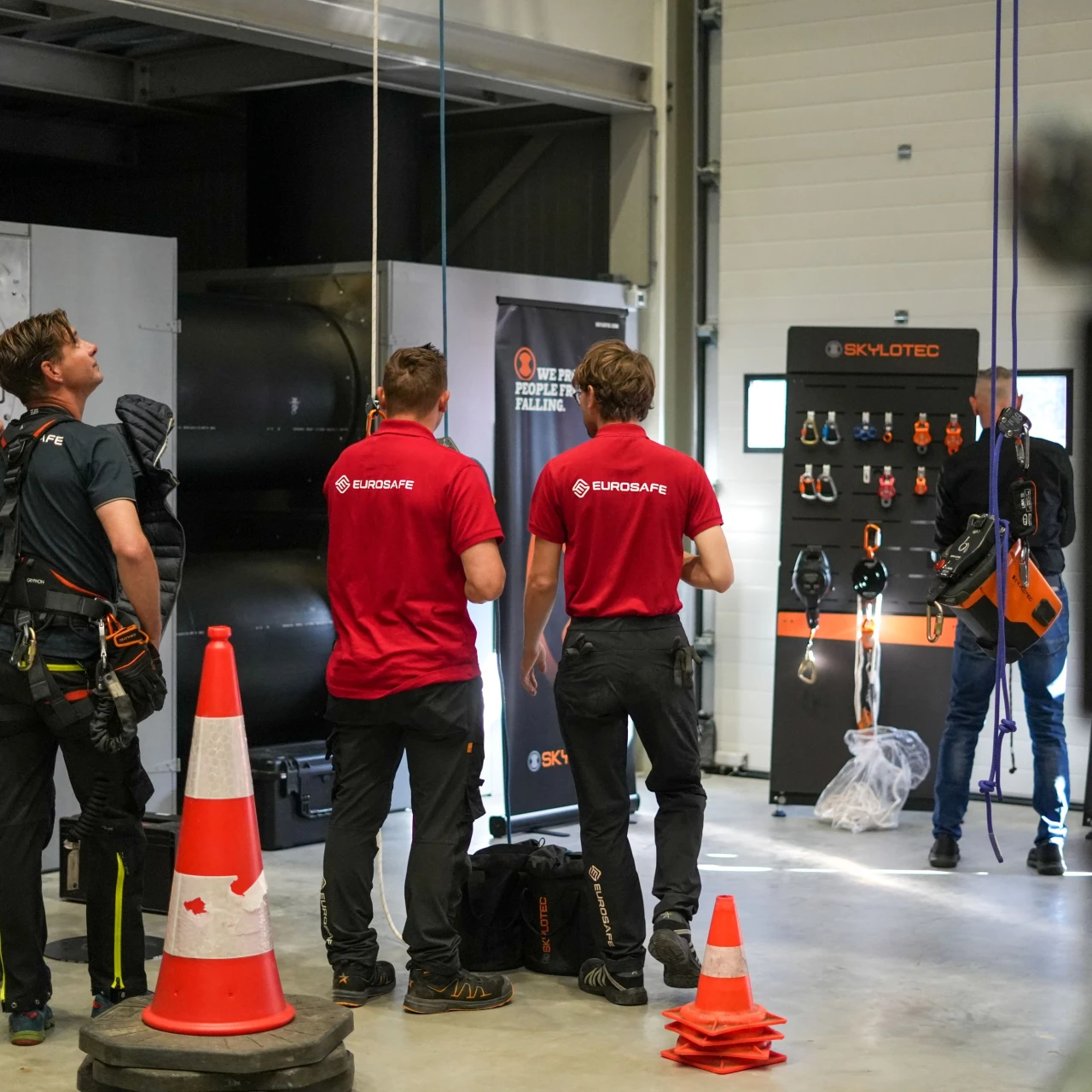 Mensen van eurosafe die staan bij een stand van skylotec kijkend naar de demonstratie