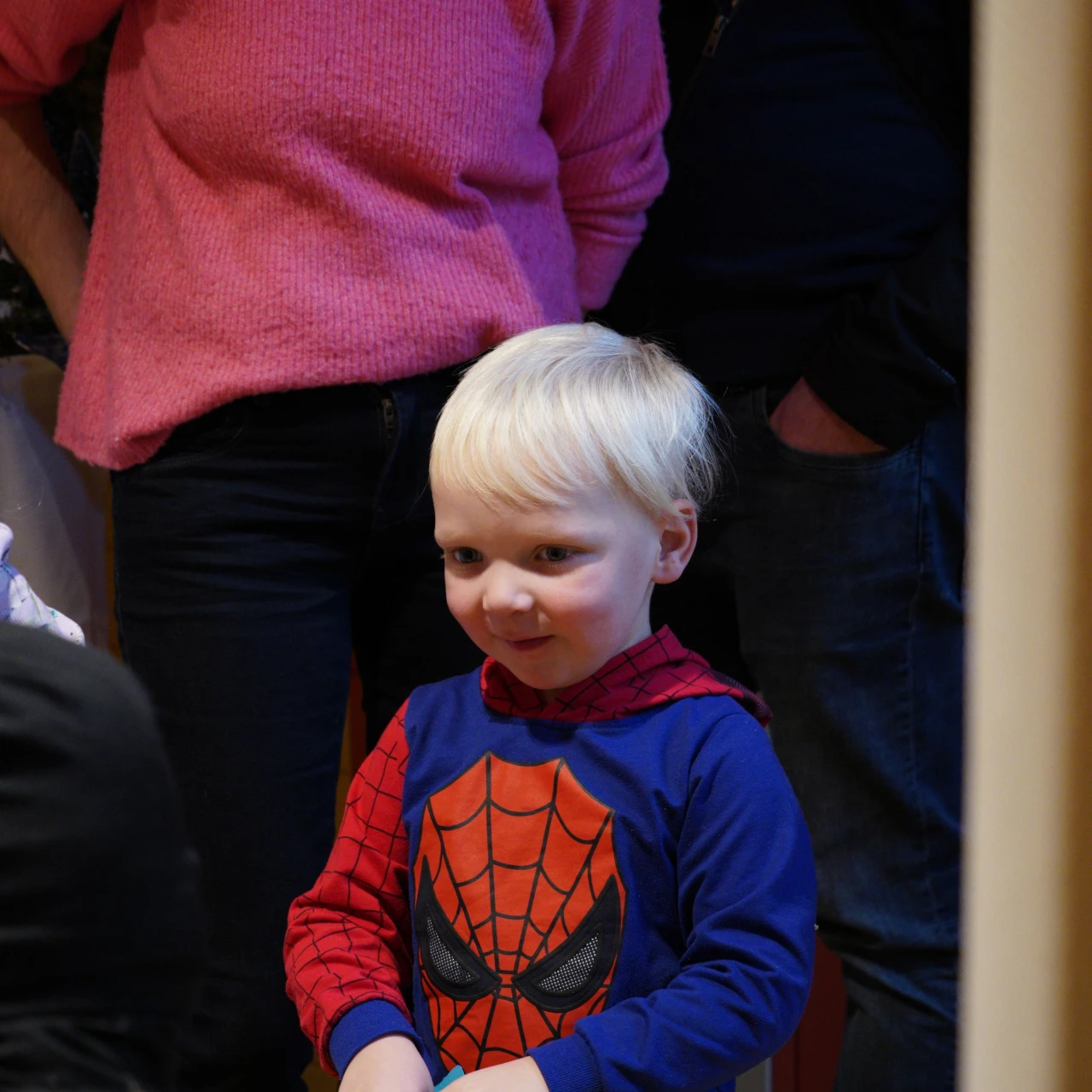 blij kind met spiderman pak aan