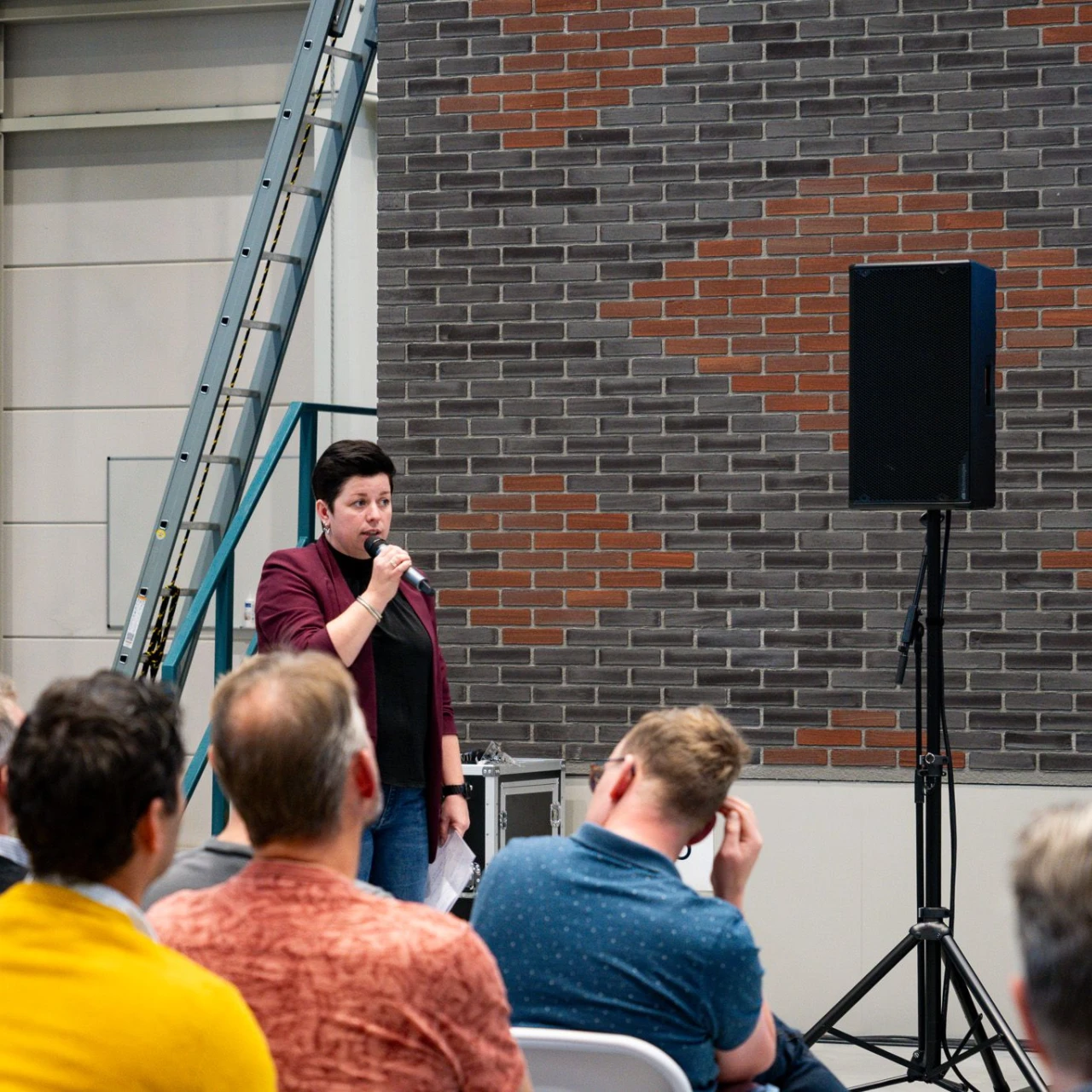 vrouw die een speech geeft voor een grote groep
