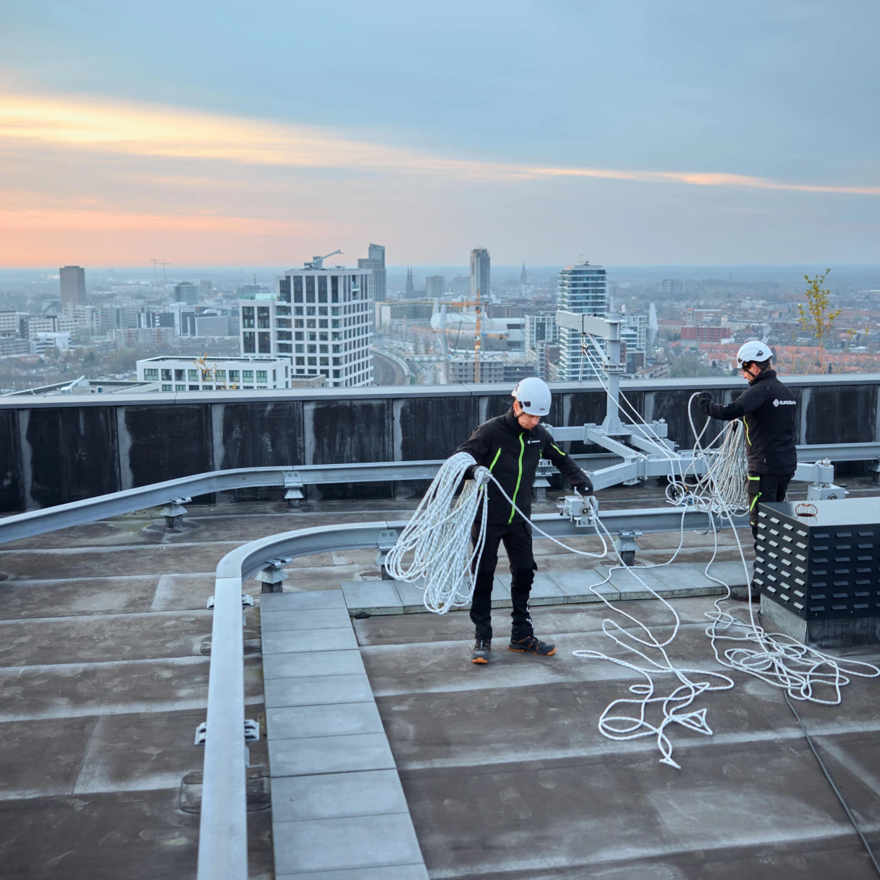mannen op hoog dak met touw en apparatuur