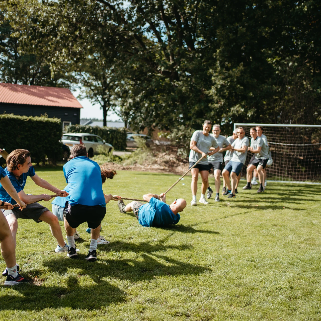 een groep die touw staat te trekken tegen een ander team en verliest