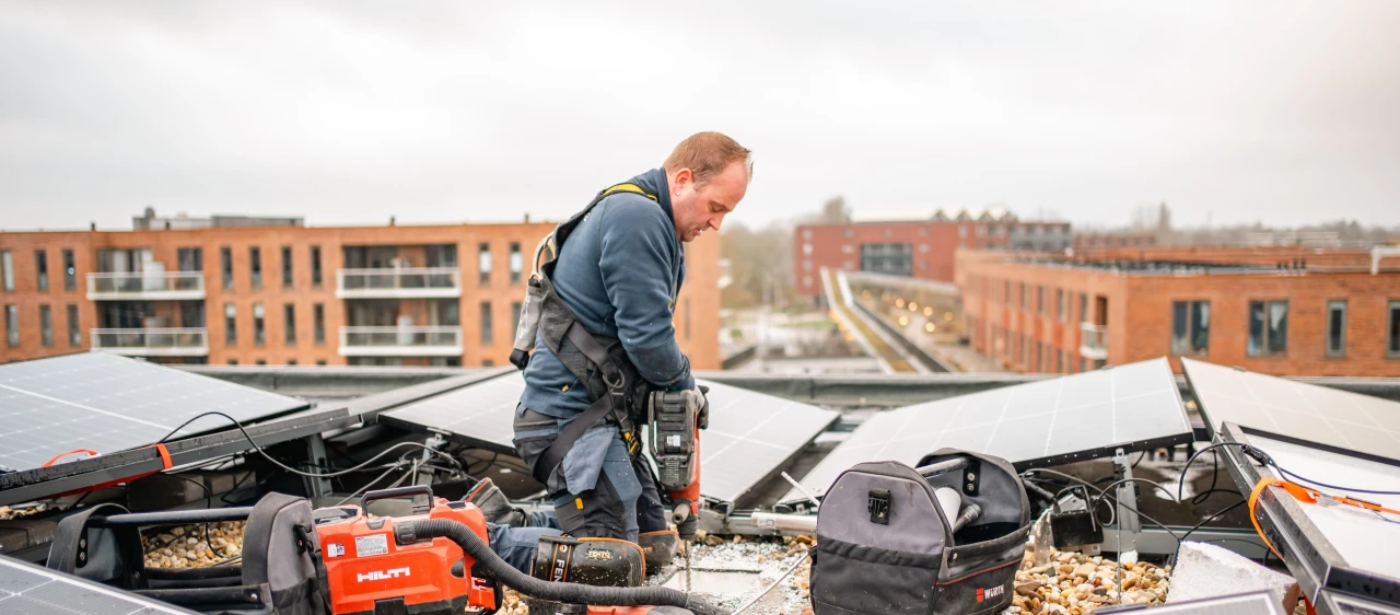 een man op een dak met zonnepanelen