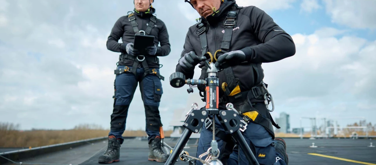 mannen op plat dak met apparatuur en helm op