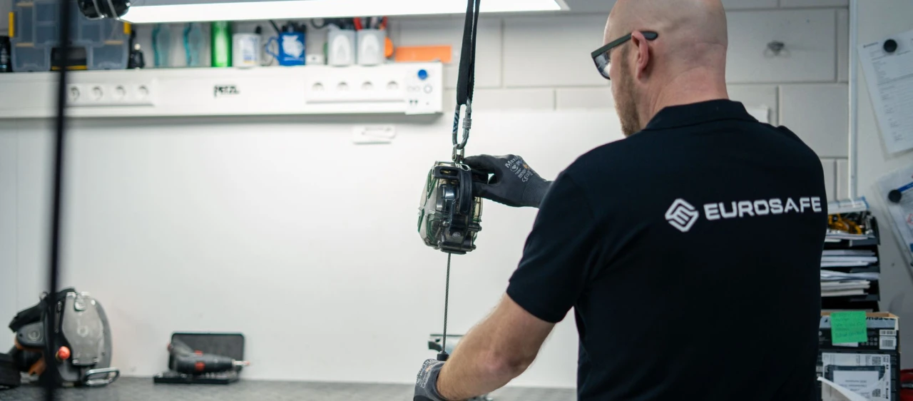 man staat met rug naar camera en houd een valblok vast