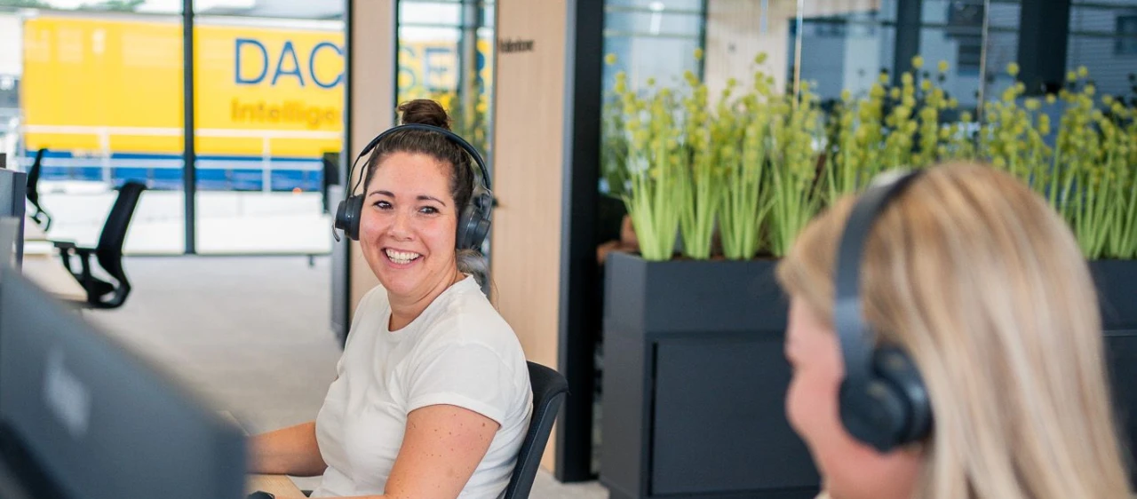 dame die lacht achter een bureau