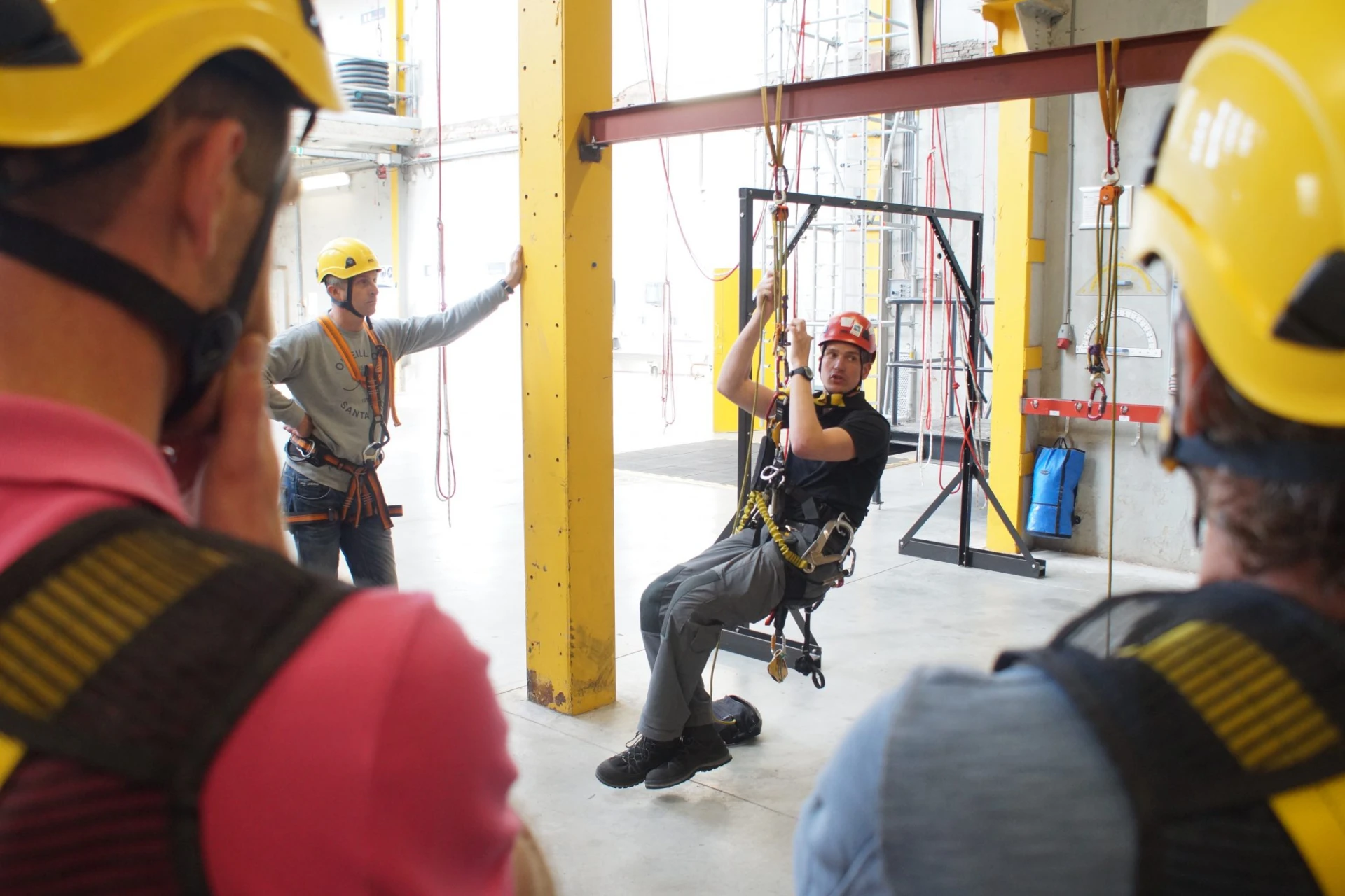 Man zit in een harnas hangend met helm op