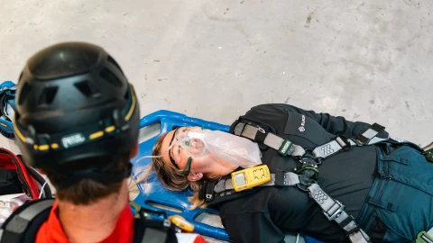 een vrouw die op een brancard ligt met zuurstof