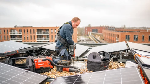 een man op een dak met zonnepanelen