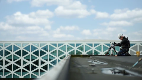 man op plat dak met apparatuur