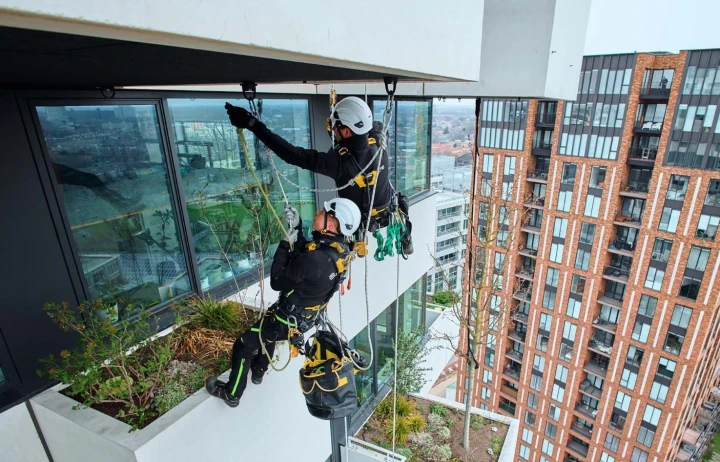 twee mannen met helm en harnas hangend aan dak