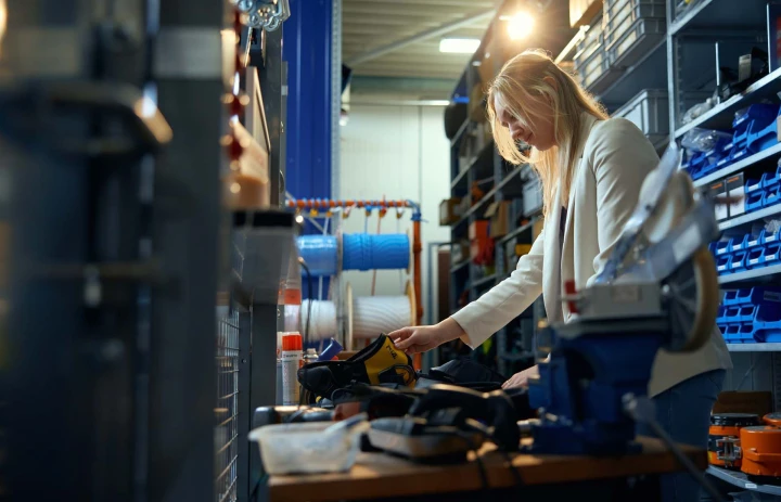 vrouw in magazijn met veiligheidsproducten