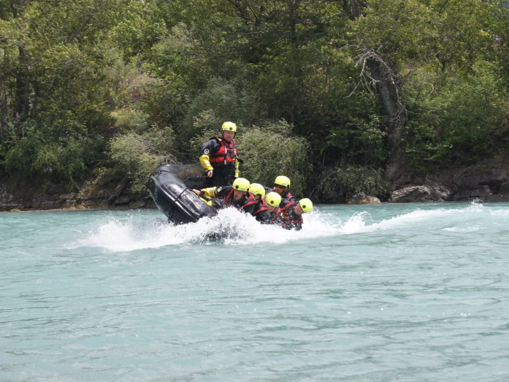 personen op boot op water met helm op en reddingsvest aan